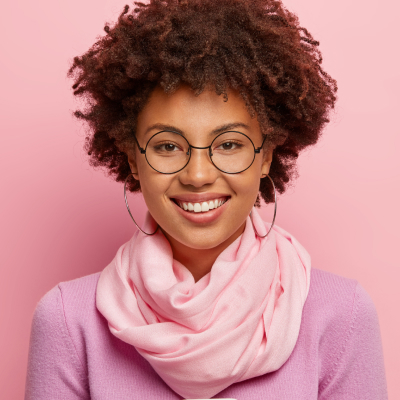 Black woman con glasses and pink sweater and scarf